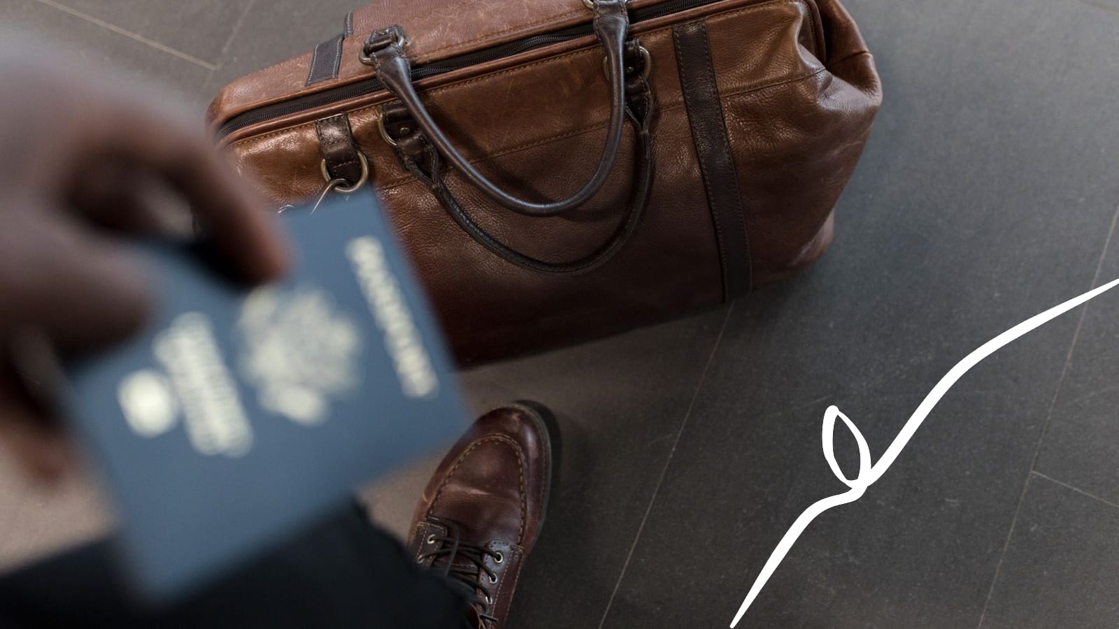 A passport held above a travel bag before a move abroad